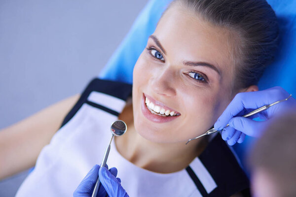 Young Female patient with pretty smile examining dental inspection at dentist office.