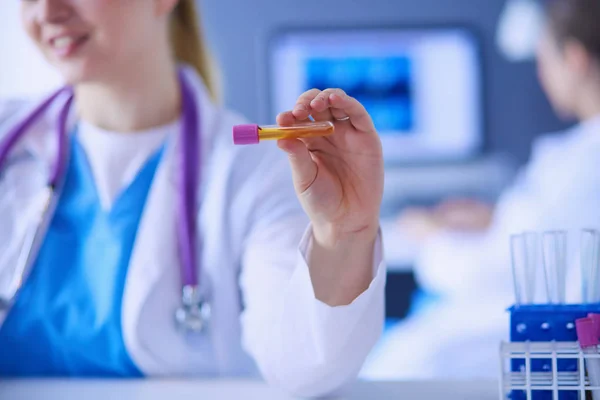 Laborassistent hält Reagenzglas, Nahsicht auf das Reagenzglas fokussiert. — Stockfoto