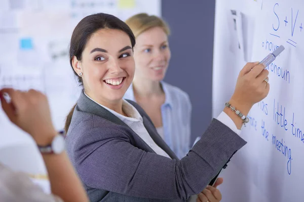 Conceito de negócios, educação e escritório - equipe de negócios com flip board no escritório discutindo algo. — Fotografia de Stock