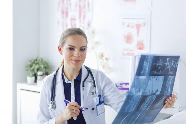 Giovane attraente medico femminile guardando l'immagine a raggi X — Foto Stock