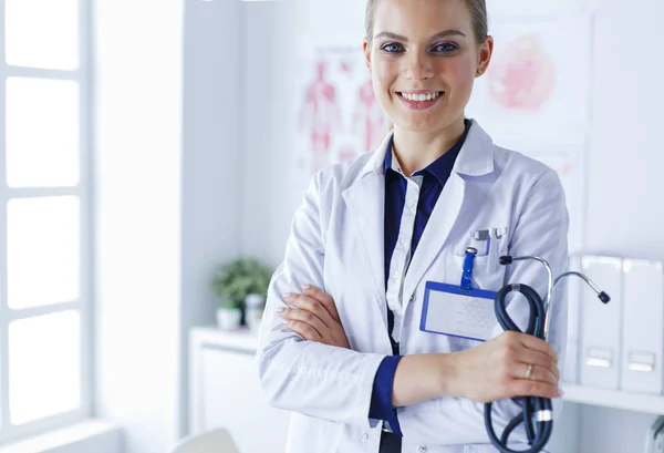 Lächelnde Ärztin mit Ordner in Uniform im Stehen — Stockfoto