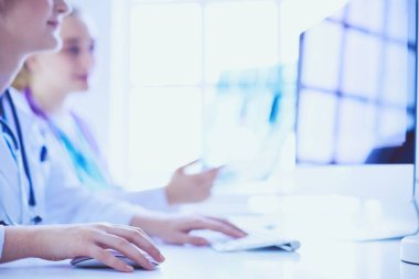 Kadın doktorlar hastanede röntgen görüntülerini inceliyor ve tartışıyorlar..