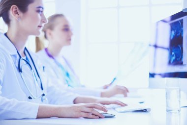 Hastanede bilgisayarla çalışan iki genç bayan doktor..