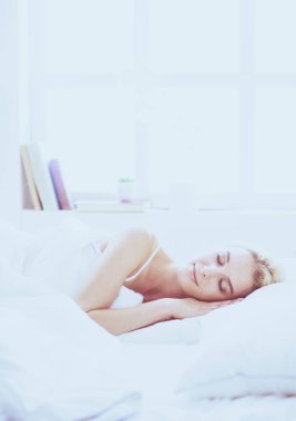 Güzel bir kadın yatağında uzanıyor.