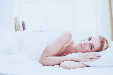 Güzel bir kadın yatağında uzanıyor..