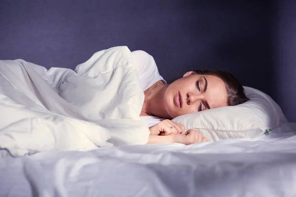 Όμορφη νεαρή ξανθιά γυναίκα στον ύπνο στο κρεβάτι — Φωτογραφία Αρχείου