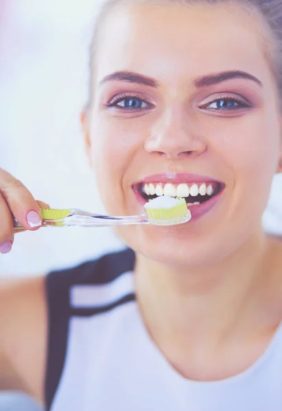 Joven chica bonita manteniendo la higiene bucal con cepillo de dientes . — Foto de Stock