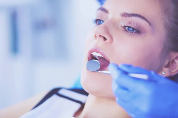 Mujer joven con la boca abierta examinando la inspección dental en el consultorio del dentista. — Foto de Stock