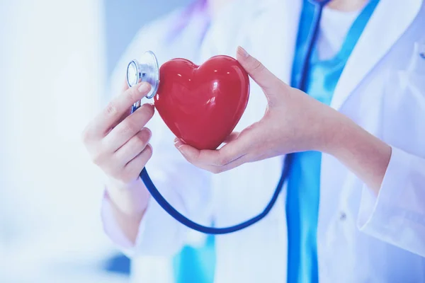 Pouls recadré de deux jeunes médecins femelle avec stéthoscope tenant le cœur. — Photo