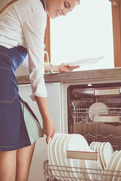 Посудомийна машина. Молода жінка на кухні виконує домашнє завдання. прання — стокове фото