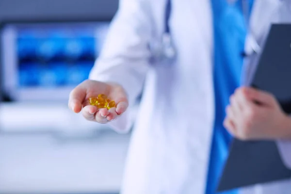 Крупный план врачей, держащих в руках таблетки в клинике. — стоковое фото