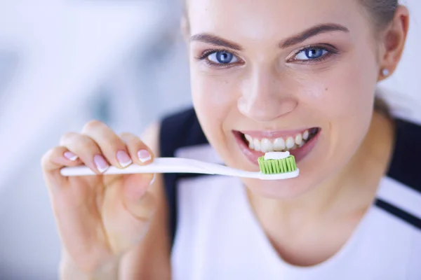 Junges hübsches Mädchen pflegt Mundhygiene mit Zahnbürste. — Stockfoto