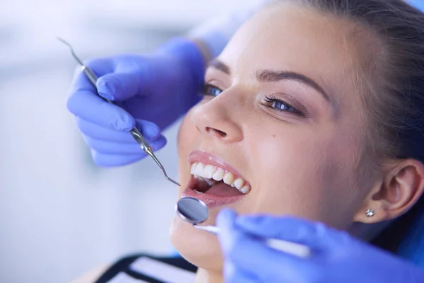 Dişçi muayenehanesinde diş muayenesi yapan ağzı açık genç bir kadın hasta.. — Stok fotoğraf