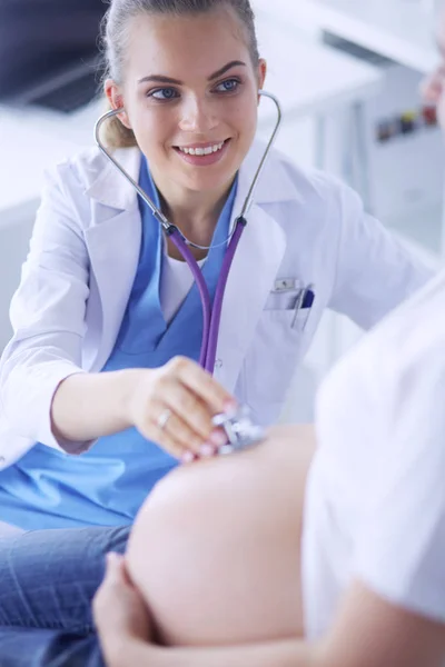 Giovane medico donna esaminando donna incinta presso la clinica. — Foto Stock