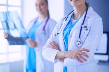 Doktorların yakın plan çekimleri ve arka planda röntgen olan meslektaşlar..
