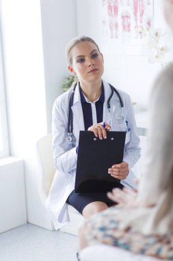 Doktor ve hasta masada otururken bir şey tartışıyorlar. İlaç ve sağlık hizmetleri kavramı