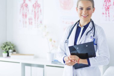 Üniformalı bir dosyayla gülümseyen kadın doktor