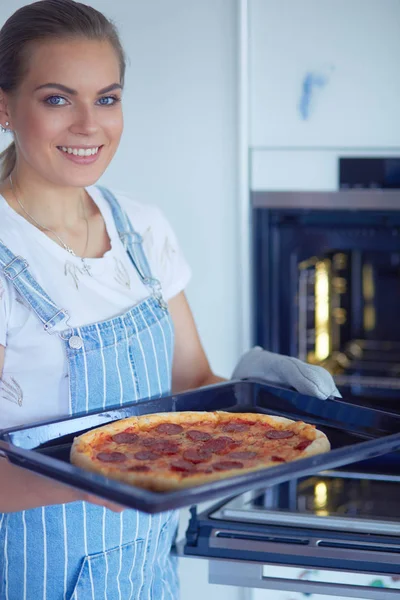 Happy young woman cooking pizza at home — Stock Photo, Image