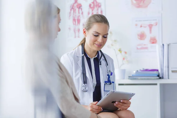 Dottore e paziente discutono di qualcosa mentre sono seduti al tavolo. Medicina e concetto di assistenza sanitaria — Foto Stock