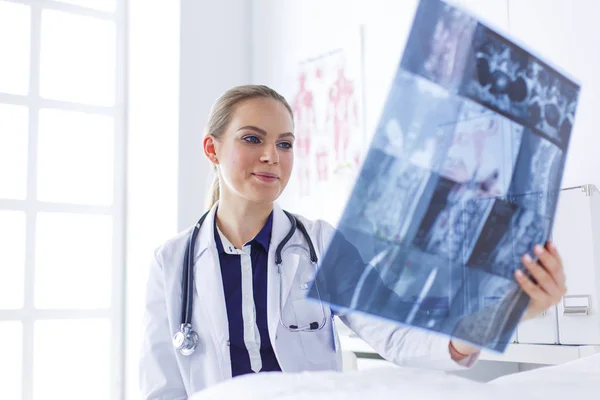 Giovane attraente medico femminile guardando l'immagine a raggi X — Foto Stock