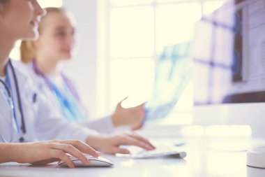 Kadın doktorlar hastanede röntgen görüntülerini inceliyor ve tartışıyorlar..