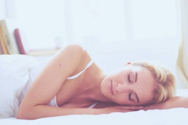 Güzel bir kadın yatağında uzanıyor.
