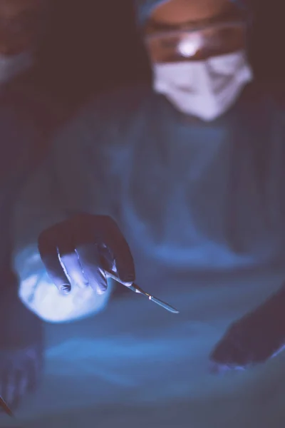 Imagem recortada de bisturi levou médicos realizando cirurgia. — Fotografia de Stock