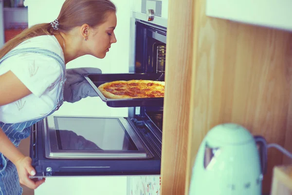 Feliz joven cocinando pizza en casa — Foto de Stock