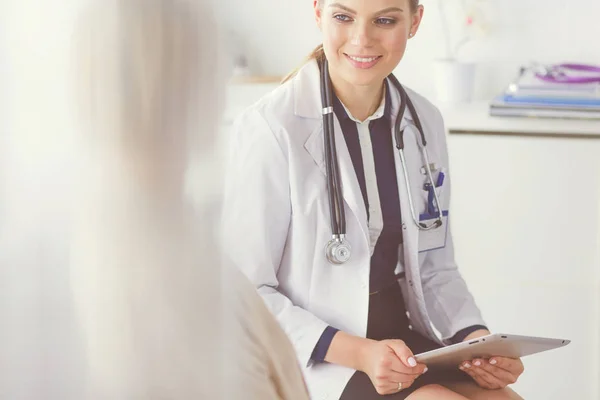 Docteur et patient discutant de quelque chose assis à la table. Médecine et soins de santé concept — Photo