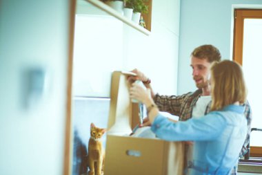 Genç bir çift yeni evde büyük karton kutu taşıyan. Ev taşıma. Genç Çift