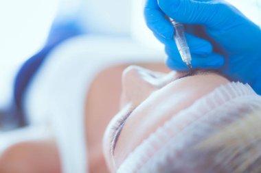 Kaşlar için kalıcı makyaj. Güzellik salonunda kalın kaşlı güzel bir kadın..