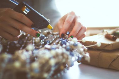 Masada oturan Noel süslemeleri aksesuarları hazırlama kadın.