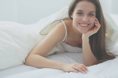 Güzel bir kadın yatağında uzanıyor..