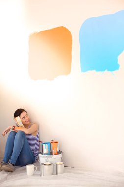 Kadın seçerek boya rengi renk örneği yeni ev ahşap yere oturmak için. Kadın evde