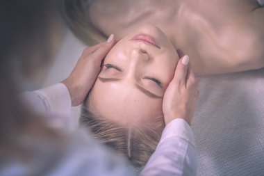 Masaj masasında uzanmış gözleri kapalı rahatlayan genç bir kadın. - Kadın. Spa salonu