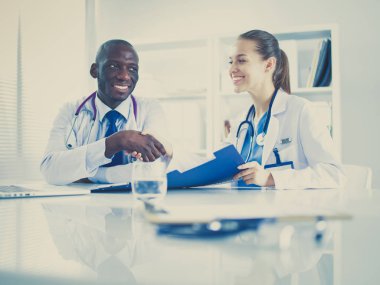 Ofiste tokalaşırken gülümseyen iki genç doktor..