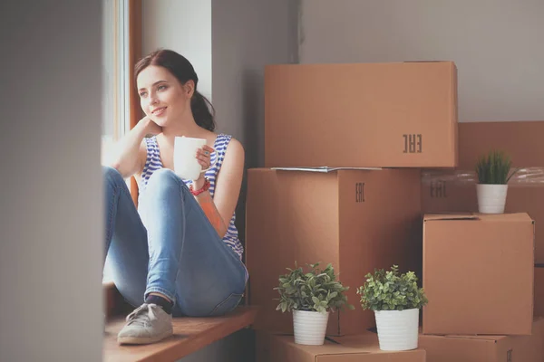 Woman in a new home with cardboard boxes. Woman in the house. — Stock Photo, Image