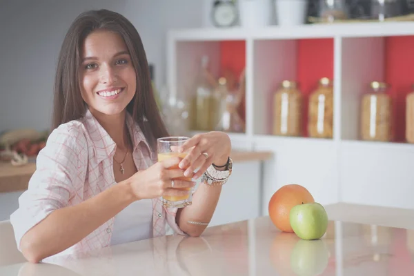 Jonge vrouw zit aan een tafel in de keuken. Jonge vrouw — Stockfoto