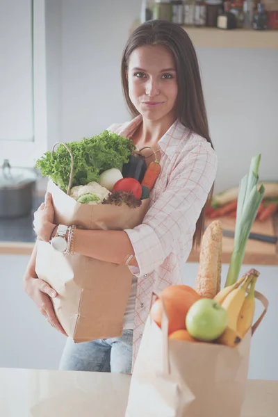 野菜の入った食料品の買い物袋を持っている若い女性。若い女性 — ストック写真