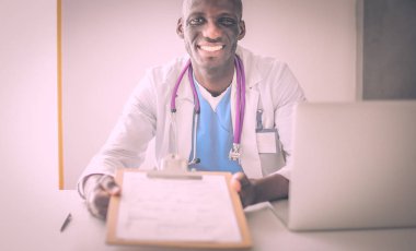 Masada dizüstü bilgisayarda çalışan genç bir Afrikalı doktor.