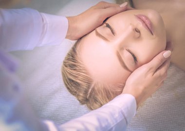 Masaj masasında uzanmış gözleri kapalı rahatlayan genç bir kadın. - Kadın. Spa salonu