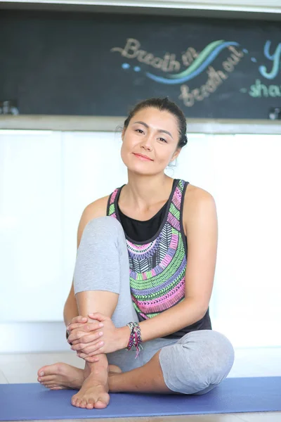 Portret van yoga vrouw zitten in yoga mat na training in yogastudio glimlachen. Yoga. Vrouw. — Stockfoto