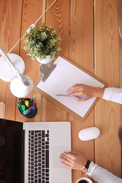 Jeune femme travaillant assise à un bureau. — Photo