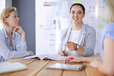 Masada kitaplarla çalışan gençler. Güzel kadınlar ve erkekler birlikte çalışıyor..