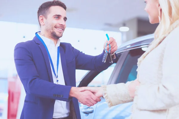 Imagem do negociante de carro handshaking com fêmea feliz no centro do automóvel — Fotografia de Stock