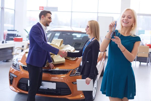 Žena obdrží klíče od auta od prodejce — Stock fotografie
