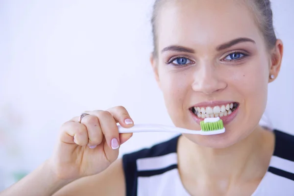 Joven chica bonita manteniendo la higiene bucal con cepillo de dientes . — Foto de Stock