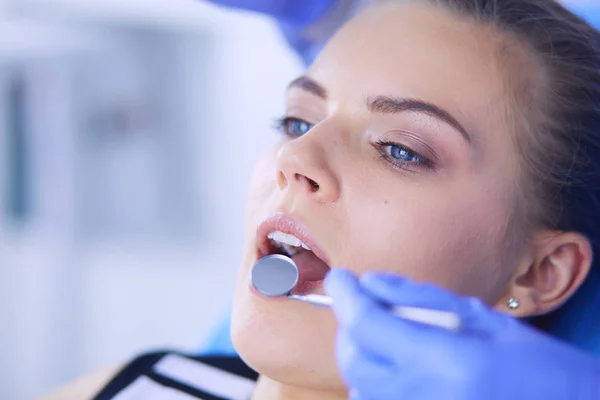 Mujer joven con la boca abierta examinando la inspección dental en el consultorio del dentista. — Foto de Stock