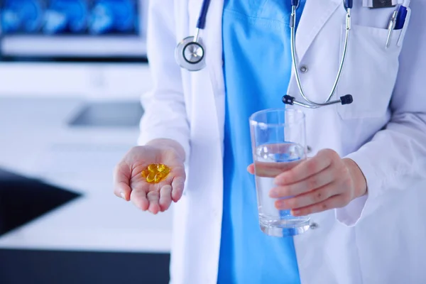 Coup de mains de médecins tenant des pilules et un verre d'eau à la clinique. — Photo