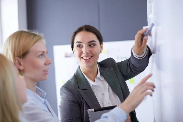 Business, education and office concept - business team with flip board in office discussing something. — Stock Photo, Image